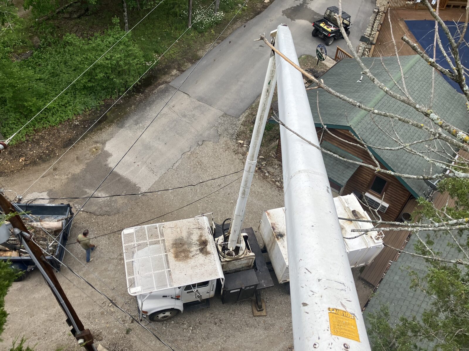 Working from the bucket near the cabin and utility lines.